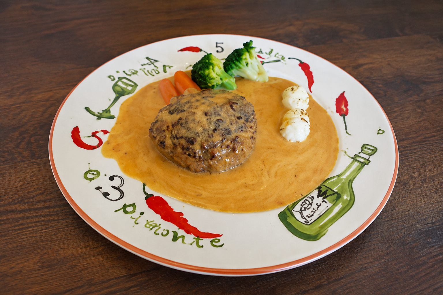 たっぷりのソースで仕上げたハンバーグと季節の付け合わせ