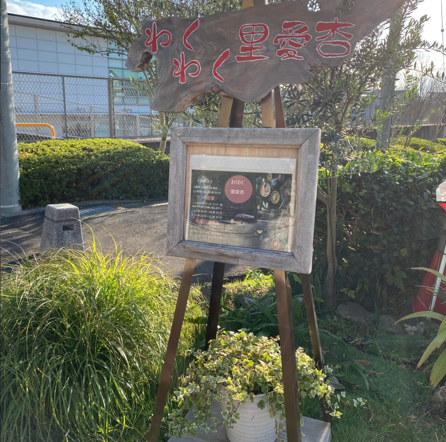 店先に立つ、木で作られたわくわく里愛杏の看板